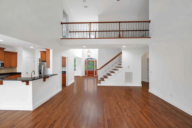 7157 Chessington Dr, Fairview, TN 37062 - kitchen with appliances with stainless steel finishes, open floor plan, dark countertops, a towering ceiling, and dark wood-style floors