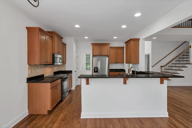 7157 Chessington Dr, Fairview, TN 37062 - kitchen featuring appliances with stainless steel finishes, a peninsula, a breakfast bar, crown molding, and recessed lighting