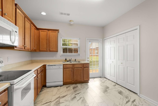 1101 Downs Blvd Unit 112, Franklin, TN 37064 - kitchen featuring white appliances, light marble finish flooring, recessed lighting, brown cabinetry, and light countertops