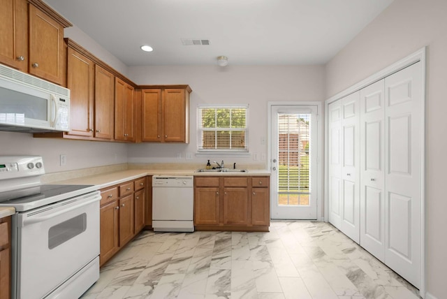 1101 Downs Blvd Unit 112, Franklin, TN 37064 - kitchen with white appliances, light marble finish flooring, recessed lighting, brown cabinets, and light countertops