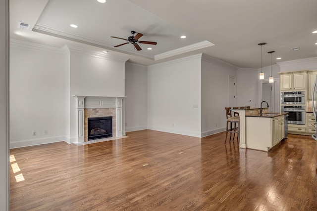 1353 Eliot Rd, Franklin, TN 37064 - unfurnished living room with a ceiling fan, wood finished floors, a tray ceiling, a tile fireplace, and recessed lighting