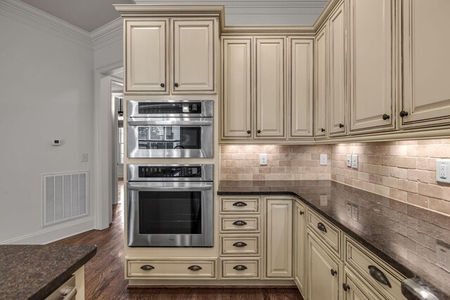 1353 Eliot Rd, Franklin, TN 37064 - kitchen featuring cream cabinets, crown molding, double oven, tasteful backsplash, and dark wood-style floors