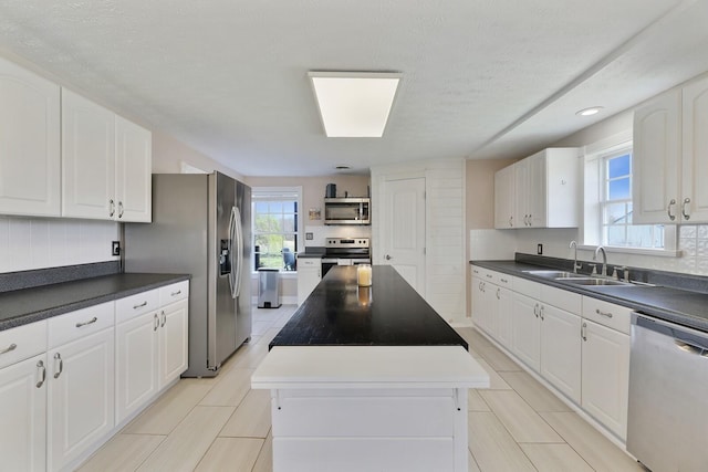 3717 Atkins Rd, Cedar Hill, TN 37032 - kitchen featuring appliances with stainless steel finishes, a center island, dark countertops, white cabinetry, and recessed lighting