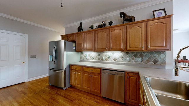 5142 Reagan Dr, Murfreesboro, TN 37129 - kitchen featuring stainless steel appliances, crown molding, light wood-style flooring, backsplash, and light countertops