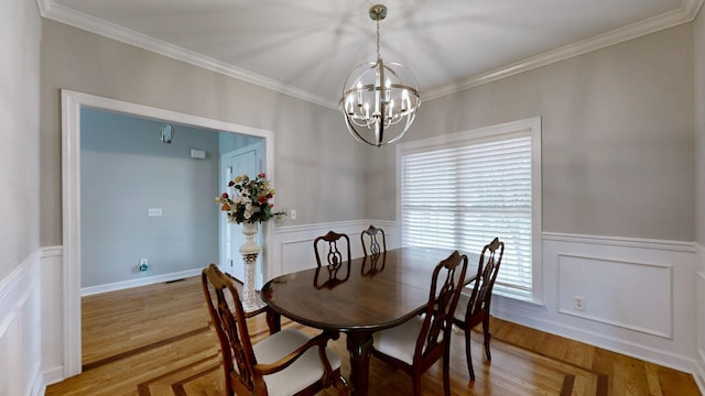 5142 Reagan Dr, Murfreesboro, TN 37129 - dining area with a chandelier, ornamental molding, a wainscoted wall, wood finished floors, and a decorative wall