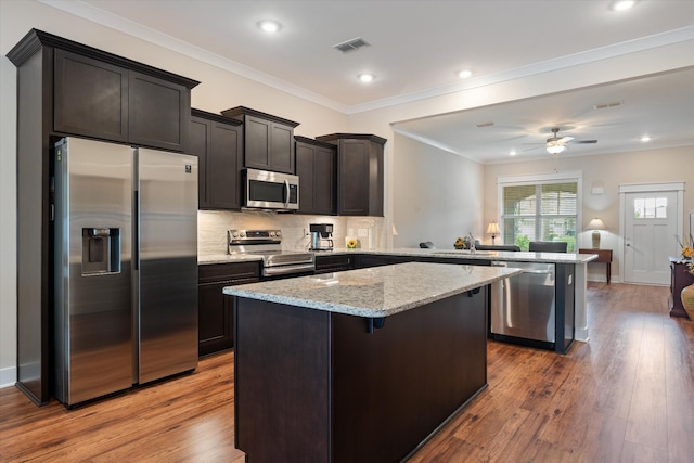 2129 Halfmoon Way, Murfreesboro, TN 37130 - kitchen featuring appliances with stainless steel finishes, a peninsula, a ceiling fan, a kitchen island, and wood finished floors