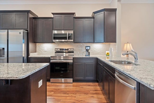 2129 Halfmoon Way, Murfreesboro, TN 37130 - kitchen featuring appliances with stainless steel finishes, light stone countertops, light wood finished floors, tasteful backsplash, and crown molding