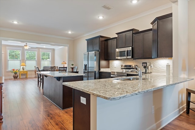 2129 Halfmoon Way, Murfreesboro, TN 37130 - kitchen with stainless steel appliances, a kitchen bar, light stone countertops, a peninsula, and dark wood-style flooring