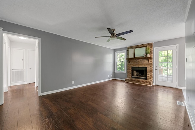 1731 Broadripple Dr, Clarksville, TN 37042 - unfurnished living room featuring a ceiling fan, a textured ceiling, a brick fireplace, and dark wood-style floors