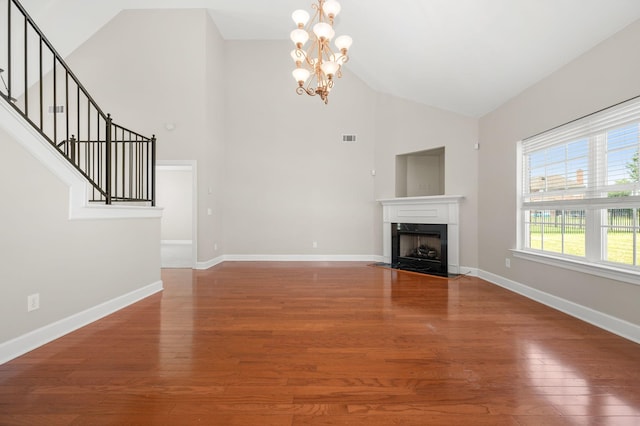 5241 Ticonderoga Ave, Murfreesboro, TN 37129 - unfurnished living room with high vaulted ceiling, a chandelier, wood finished floors, stairs, and a fireplace with flush hearth