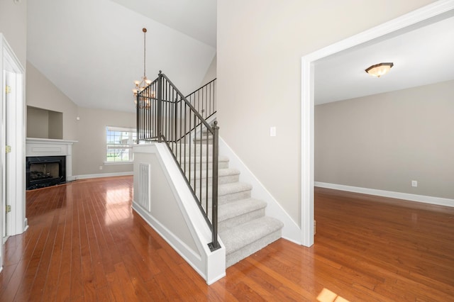 5241 Ticonderoga Ave, Murfreesboro, TN 37129 - stairway featuring a chandelier, hardwood / wood-style floors, high vaulted ceiling, and a fireplace with raised hearth