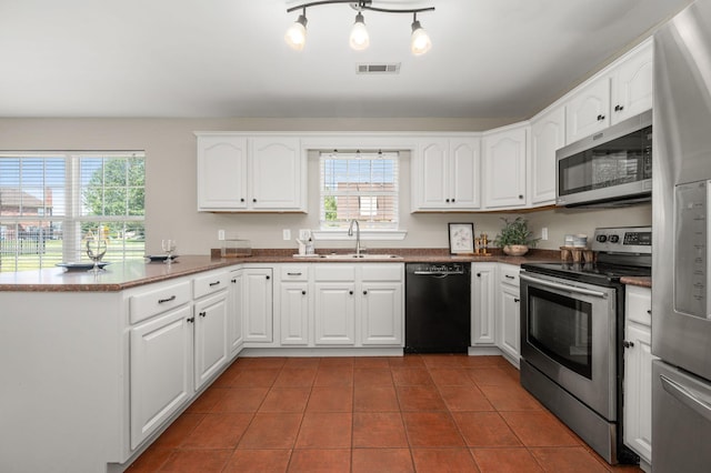 5241 Ticonderoga Ave, Murfreesboro, TN 37129 - kitchen featuring stainless steel appliances, a peninsula, tile patterned flooring, white cabinetry, and dark countertops