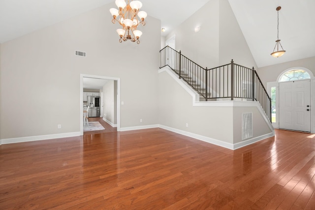 5241 Ticonderoga Ave, Murfreesboro, TN 37129 - unfurnished living room featuring high vaulted ceiling, stairway, wood-type flooring, and a chandelier