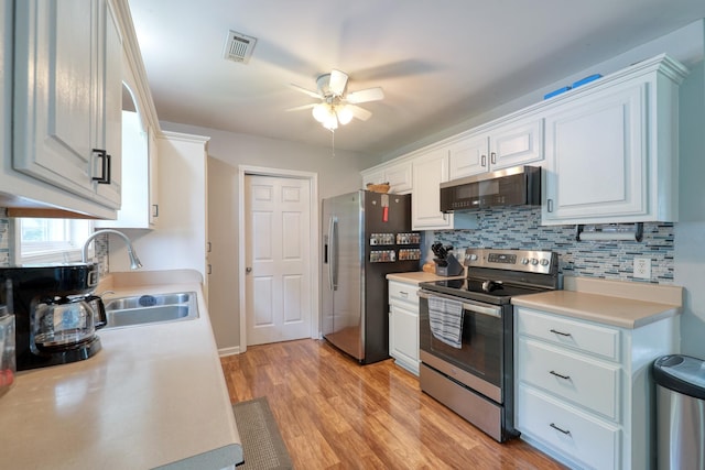 1944 Fieldstone Dr, Columbia, TN 38401 - kitchen with appliances with stainless steel finishes, ceiling fan, backsplash, light countertops, and white cabinets