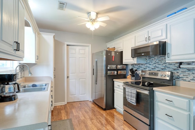 1944 Fieldstone Dr, Columbia, TN 38401 - kitchen with stainless steel appliances, ceiling fan, decorative backsplash, white cabinetry, and light wood finished floors