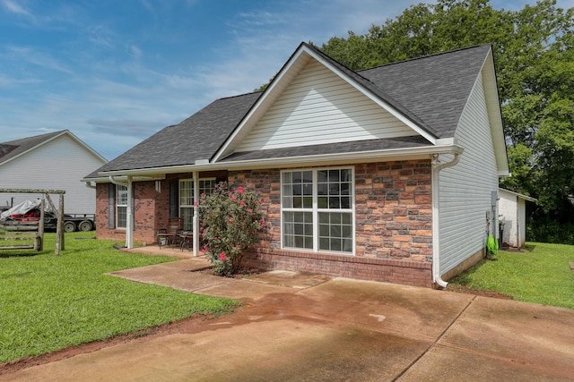 1944 Fieldstone Dr, Columbia, TN 38401 - rear view of house with a patio area, a lawn, a shingled roof, and stone siding