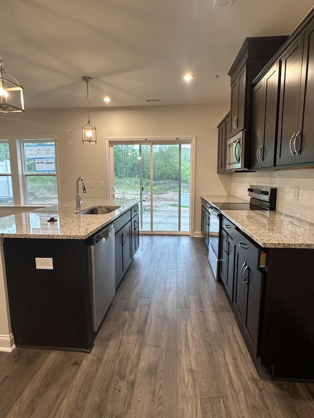 2127 Cheltenham Pl, Columbia, TN 38401 - kitchen featuring appliances with stainless steel finishes, an island with sink, dark wood-type flooring, light stone counters, and recessed lighting
