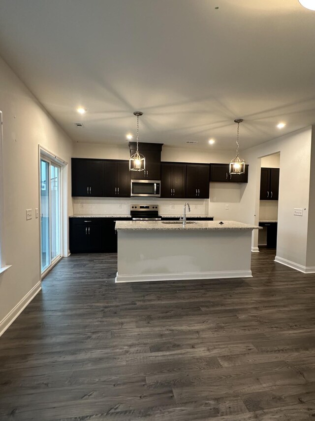 2127 Cheltenham Pl, Columbia, TN 38401 - kitchen with stainless steel appliances, dark wood finished floors, recessed lighting, a center island with sink, and dark cabinets