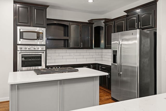 630 Black Horse Pkwy, Franklin, TN 37069 - kitchen with appliances with stainless steel finishes, tasteful backsplash, dark wood-type flooring, a center island, and recessed lighting