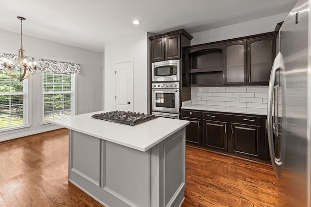 630 Black Horse Pkwy, Franklin, TN 37069 - kitchen with stainless steel appliances, a chandelier, light countertops, dark wood-style flooring, and decorative backsplash