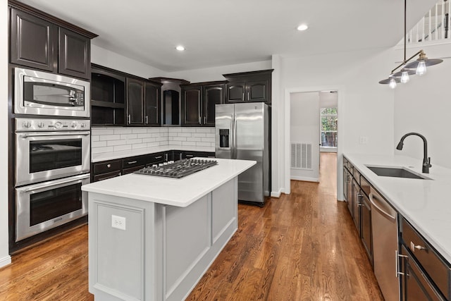 630 Black Horse Pkwy, Franklin, TN 37069 - kitchen featuring stainless steel appliances, tasteful backsplash, dark wood finished floors, light countertops, and a center island