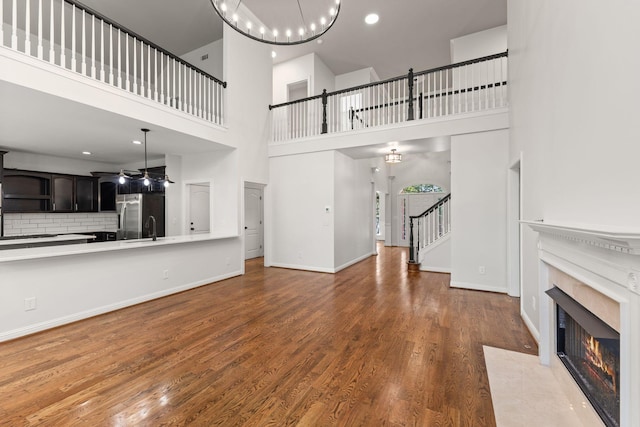 630 Black Horse Pkwy, Franklin, TN 37069 - unfurnished living room featuring a high end fireplace, stairway, wood finished floors, a high ceiling, and recessed lighting