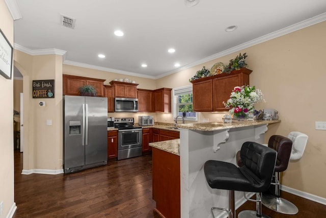 3116 Mapleside Ln, Murfreesboro, TN 37128 - kitchen with appliances with stainless steel finishes, a peninsula, dark wood-style flooring, light stone countertops, and a kitchen bar