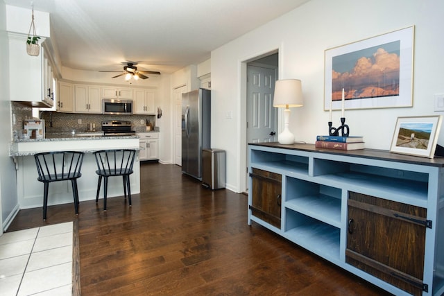 280 Ballygar Ct, Clarksville, TN 37043 - kitchen with appliances with stainless steel finishes, white cabinets, backsplash, dark wood finished floors, and a ceiling fan