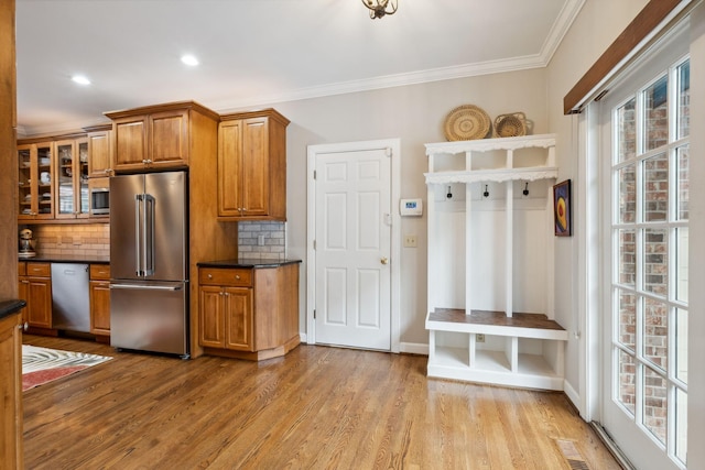 1470 Tyne Blvd, Nashville, TN 37215 - kitchen with stainless steel appliances, brown cabinets, dark countertops, tasteful backsplash, and ornamental molding