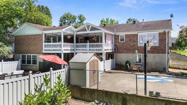 605 Jackson Ave, Carthage, TN 37030 - rear view of house featuring brick siding, a storage unit, a fenced backyard, a patio, and a balcony