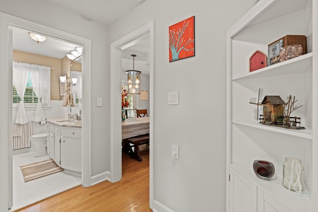 605 Jackson Ave, Carthage, TN 37030 - hallway with light wood-style flooring and a chandelier