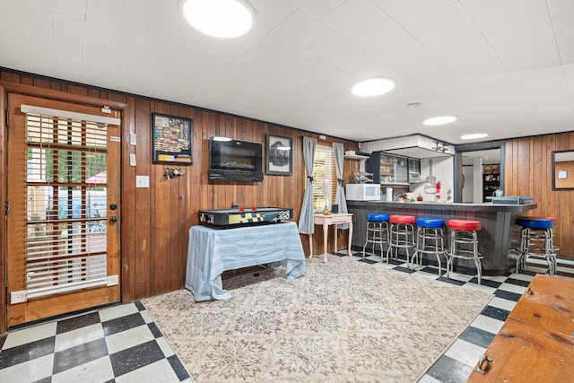 605 Jackson Ave, Carthage, TN 37030 - living area with tile patterned floors, a bar, and wood walls