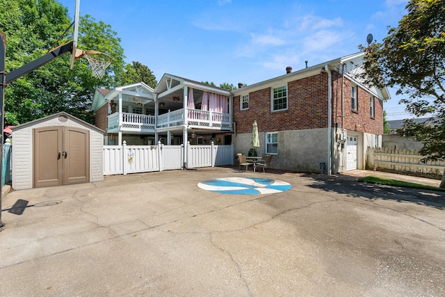 605 Jackson Ave, Carthage, TN 37030 - back of house featuring a storage unit, brick siding, a garage, and a patio area