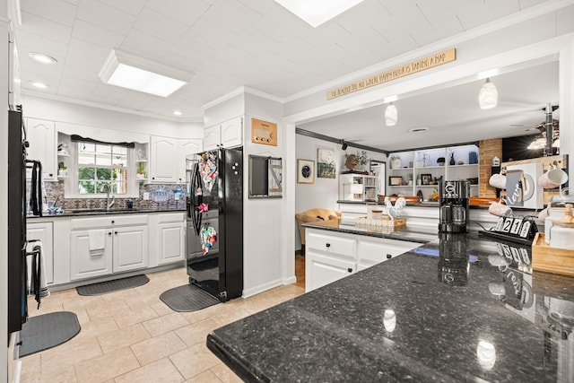 605 Jackson Ave, Carthage, TN 37030 - kitchen featuring freestanding refrigerator, ornamental molding, white cabinetry, dark stone counters, and light tile patterned floors
