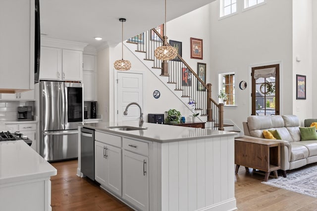 1588 Cobbler Ct, Chattanooga, TN 37421 - kitchen with appliances with stainless steel finishes, wood finished floors, white cabinets, light countertops, and decorative light fixtures