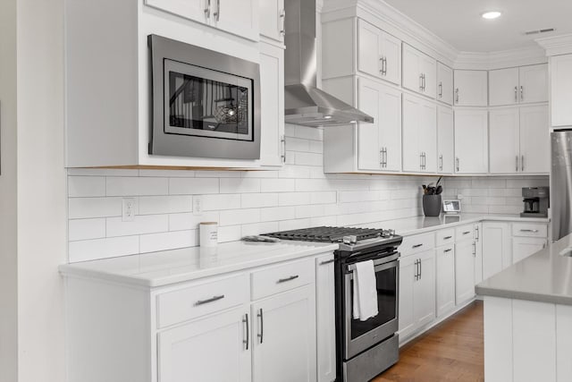 1588 Cobbler Ct, Chattanooga, TN 37421 - kitchen featuring wall chimney range hood, appliances with stainless steel finishes, light countertops, white cabinetry, and tasteful backsplash