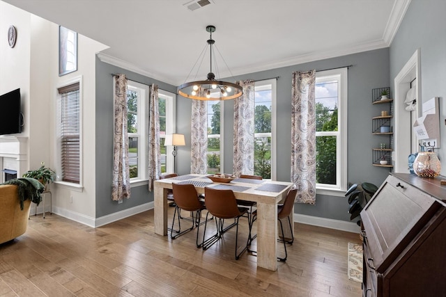 1588 Cobbler Ct, Chattanooga, TN 37421 - dining room with crown molding, a chandelier, light wood-style flooring, and a fireplace