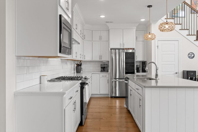 1588 Cobbler Ct, Chattanooga, TN 37421 - kitchen featuring stainless steel appliances, light countertops, decorative backsplash, decorative light fixtures, and white cabinets
