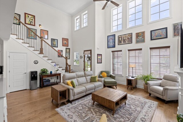 1588 Cobbler Ct, Chattanooga, TN 37421 - living room featuring stairway, ceiling fan, a high ceiling, light wood-type flooring, and crown molding