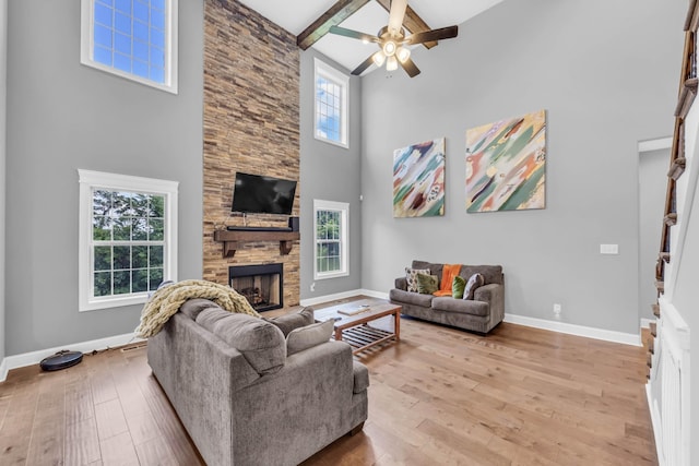 267 Alonzo Pl, Cunningham, TN 37052 - living area with a stone fireplace, a high ceiling, a ceiling fan, hardwood / wood-style flooring, and beamed ceiling