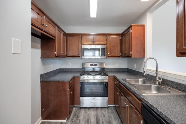 3044 Stone Bridge Rd, Antioch, TN 37013 - kitchen featuring appliances with stainless steel finishes, dark countertops, dark wood-style flooring, and brown cabinetry