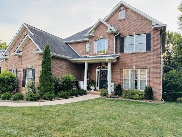 152 Yorkshire Dr, Clarksville, TN 37043 - traditional home with a front lawn, brick siding, a porch, and a shingled roof
