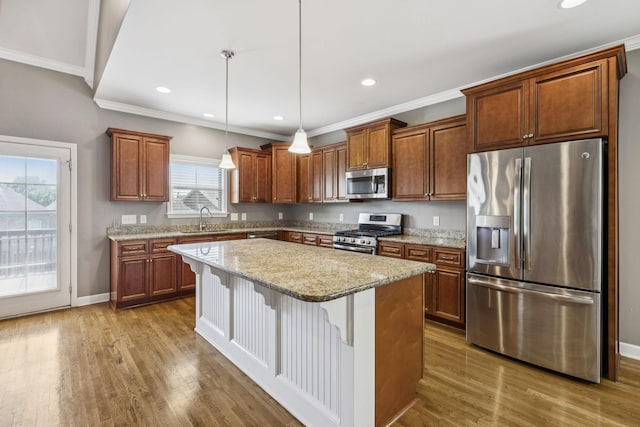8005 Ragusa Cir, Spring Hill, TN 37174 - kitchen with stainless steel appliances, ornamental molding, wood finished floors, a center island, and pendant lighting