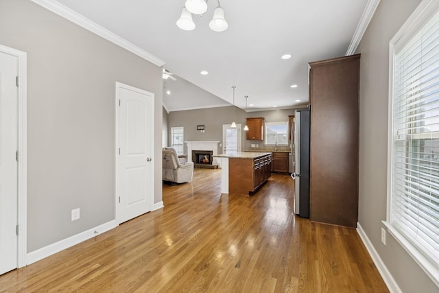 8005 Ragusa Cir, Spring Hill, TN 37174 - kitchen featuring open floor plan, ornamental molding, a center island, light countertops, and wood finished floors