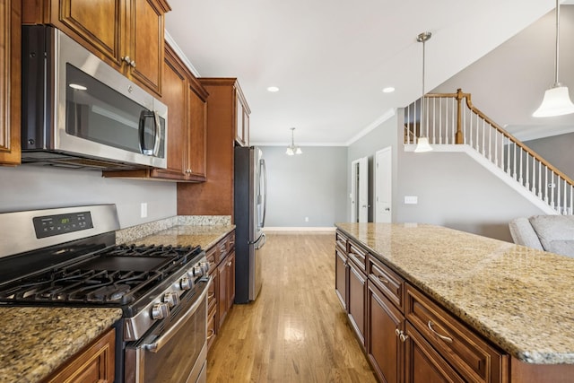 8005 Ragusa Cir, Spring Hill, TN 37174 - kitchen featuring appliances with stainless steel finishes, light wood-type flooring, ornamental molding, brown cabinets, and light stone counters
