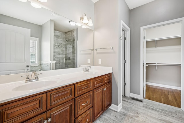 8005 Ragusa Cir, Spring Hill, TN 37174 - bathroom with a stall shower, double vanity, a walk in closet, and wood finished floors