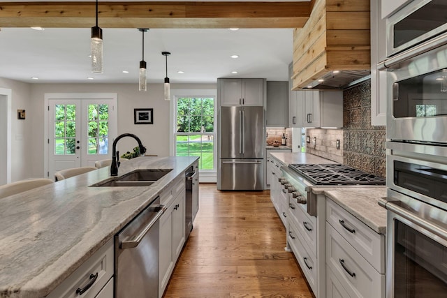 9003 Oden Ct, Brentwood, TN 37027 - kitchen featuring stainless steel appliances, custom exhaust hood, healthy amount of natural light, light wood-style floors, and recessed lighting