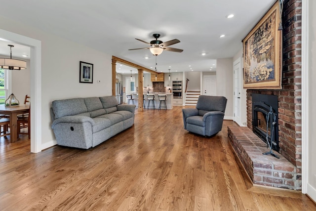 9003 Oden Ct, Brentwood, TN 37027 - living room with recessed lighting, ceiling fan, a brick fireplace, stairway, and wood finished floors
