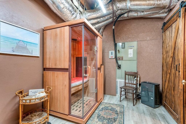 647 Omega Dr, Spring City, TN 37381 - bathroom with wood finished floors, a stall shower, a textured wall, and a sauna