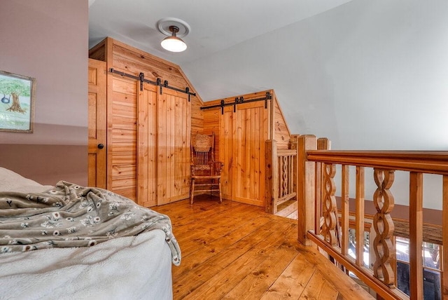 647 Omega Dr, Spring City, TN 37381 - bedroom with lofted ceiling, light wood finished floors, and a barn door